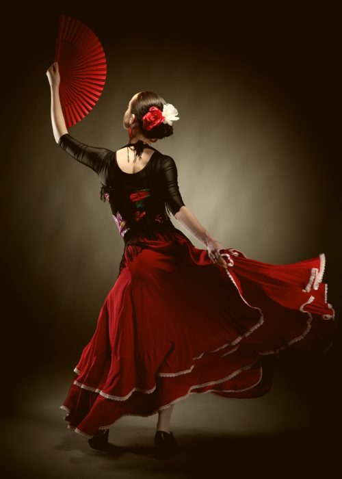 young woman dancing flamenco on black